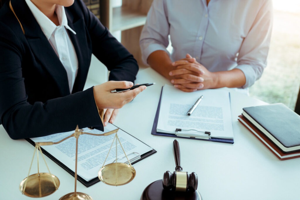 A St. Paul civil rights lawyer with a gavel and scales on his desk is shaking hands with a client.
