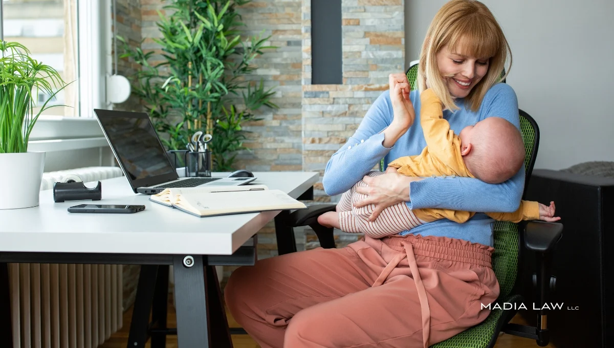 New mother working on a laptop in an office
